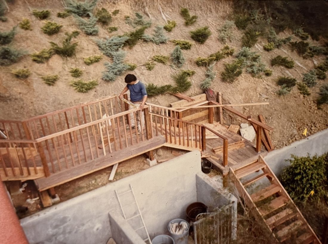 Adolfo building a hillside wooden walkway and stairs